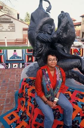 <b>Anita G. Knox with her quilts and a statue of Will Pickett, the black cowboy.</b> Tarrant Count, TX, April 1993.